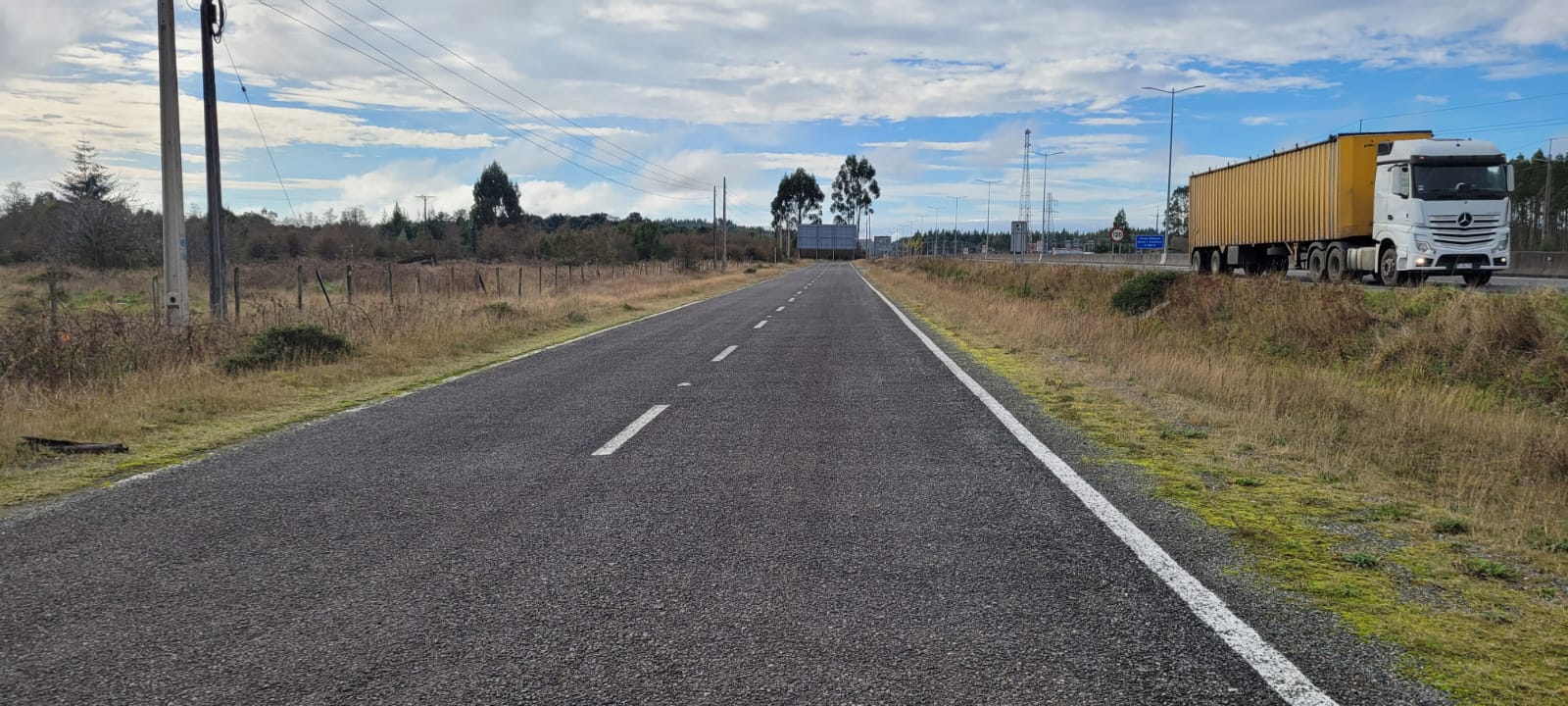Caletera asfaltada de la Ruta 5 Sur junto al predio, con tránsito de camión.